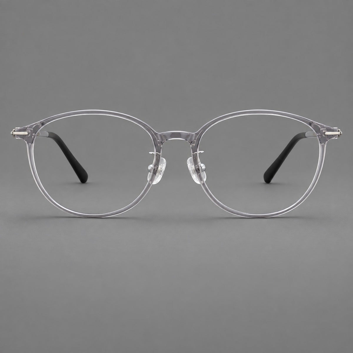 Slim oval plastic eyeglasses with a low profile and subtle metal corner accents — Clear Grey — Front view [CINILY-JD2026-2204-C1]