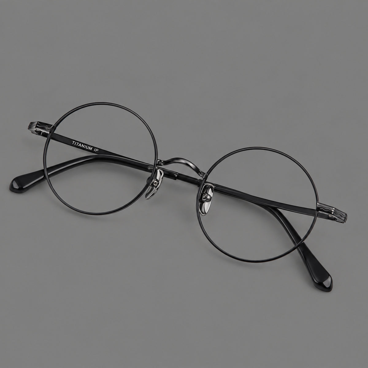 Compact circular titanium glasses with a curved bridge and wavy engraved temples — Black — Main view [CINILY-JD2026-88047-C1]