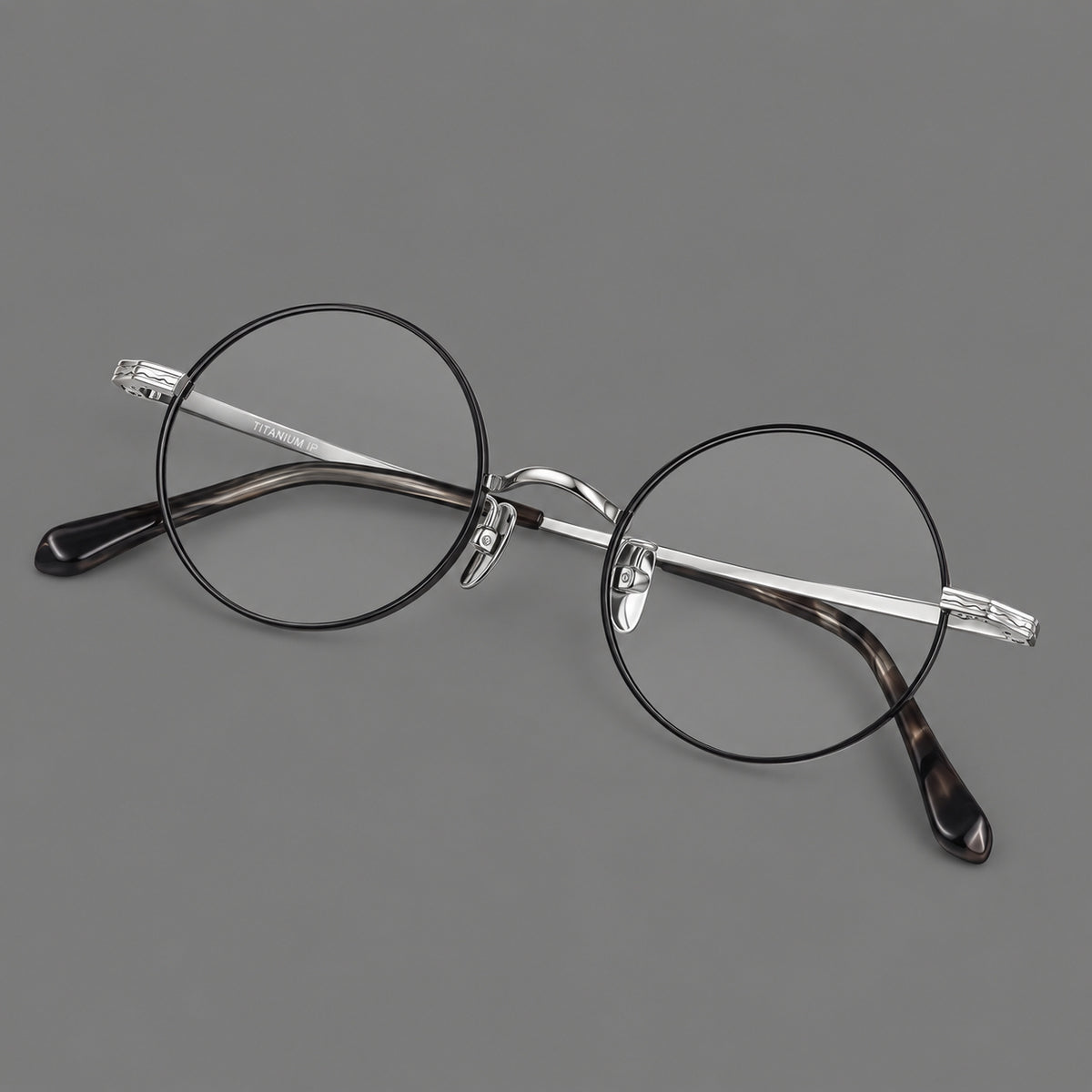 Compact circular titanium glasses with a curved bridge and wavy engraved temples — Black and Silver — Main view [CINILY-JD2026-88047-C3]